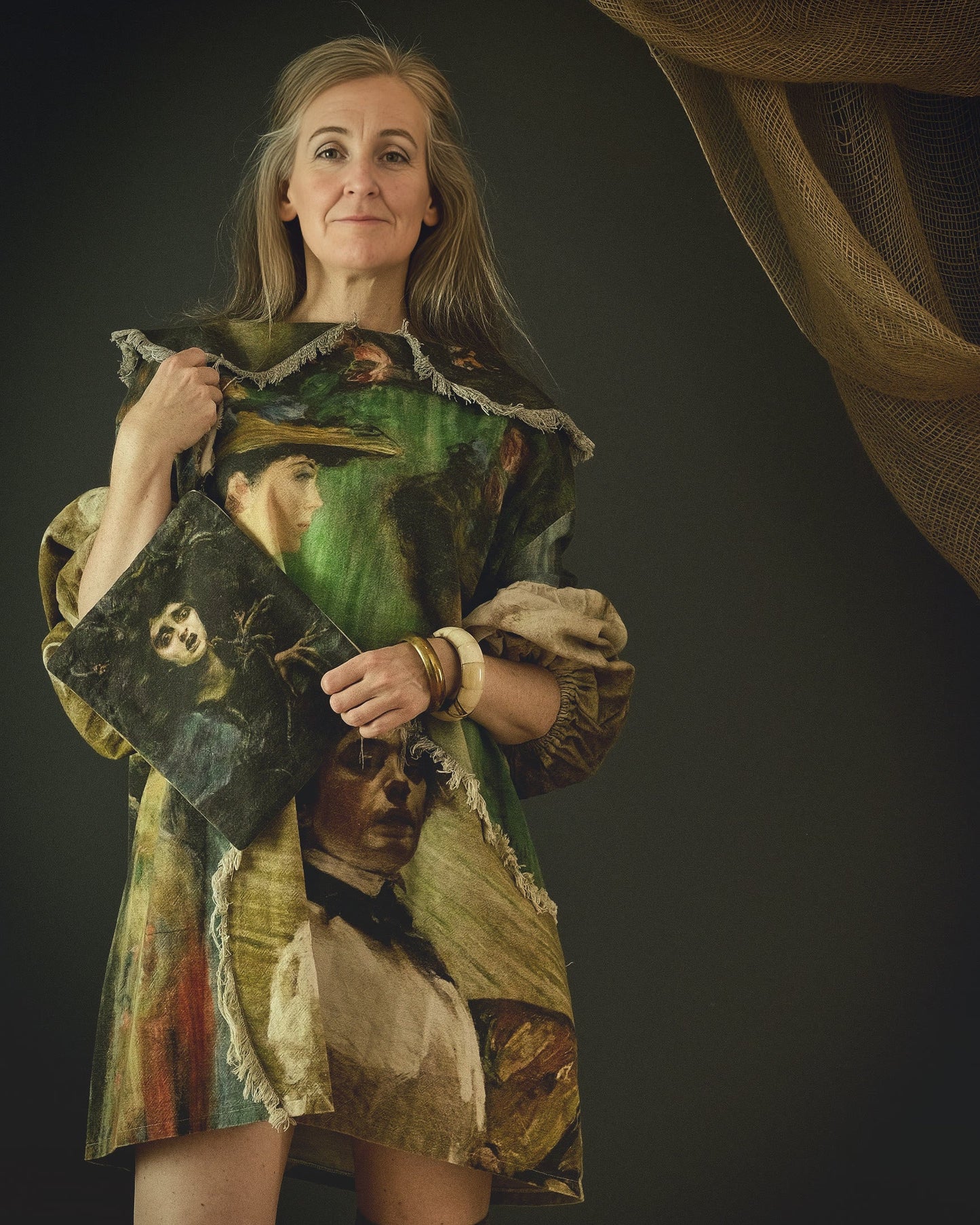 woman holding a fabric clutch and wearing a cotton linen dress with bold 19th century artwork print